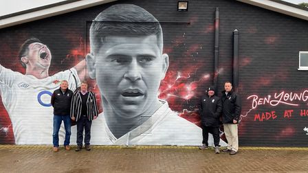 Club leaders in front of the finished Ben Youngs mural at Holt Rugby Football Club.