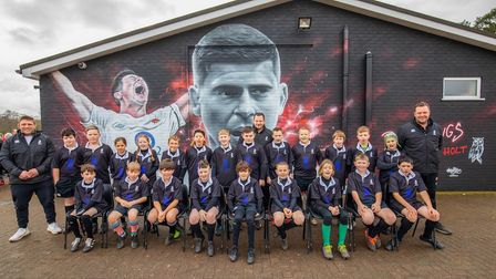 Young Holt Rugby Football Club players in front of the Ben Youngs mural at the club.