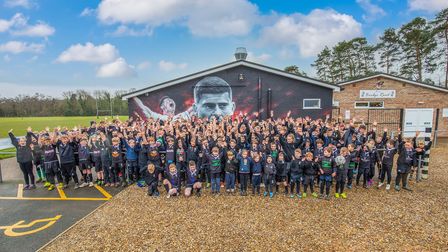 Young Holt Rugby Football Club players in front of the Ben Youngs mural at the club.