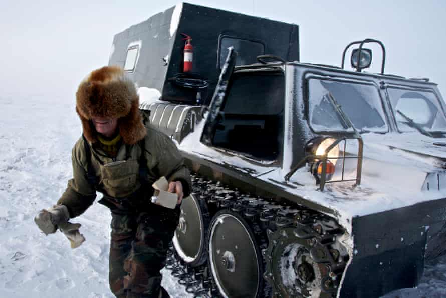 A worker delivers lightbulbs to an outpost at a drilling colony set up by oil and gas prospecting company “Siesmorevzedka” in the Arctic tundra.