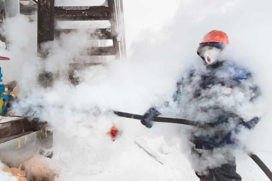 A Russian worker at a gas and condensate processing system in Novy Urengoi, Arctic Siberia, blows steam on gas pipelines to prevent them from freezing during a cold morning when temperature dropped to -42c.