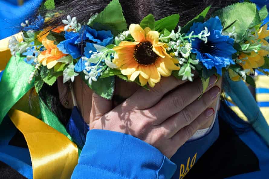 A member of the Ukrainian team cries during a moment of silence at the Zhangjiakou athletes' village
