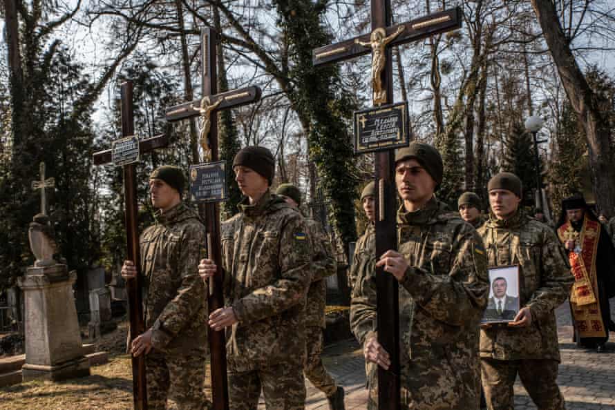 Soldiers at Lychakiv cemetery in Lviv during the funeral of four Ukrainian men.