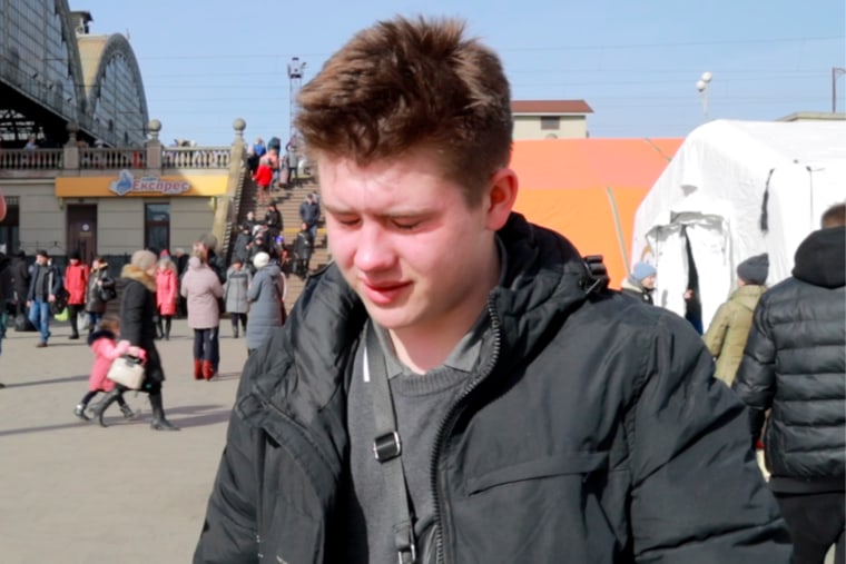 Vladyslav Hrudiy, 17, reacts after his grandmother collapsed upon their arrival in Lviv. 