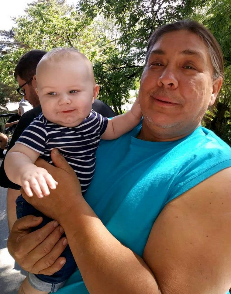 Image: Chauncey Peltier holds Leonard's great-grandson, Brayden Rand.