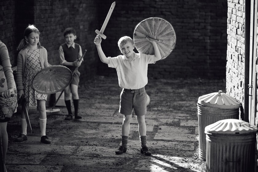 A boy plays soldier with a wooden sword and a trashcan-lid shield in a scene from 