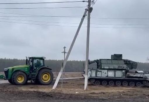 Tractorista ucraniano remolca un blindado ruso
