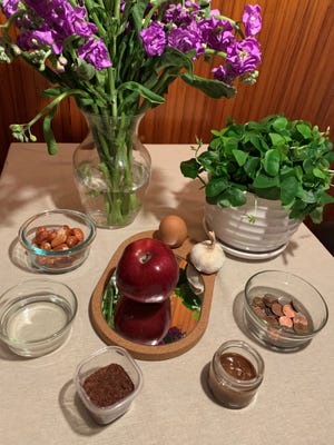 Traditional haft-seen table. Left to right: Flowers, shamrock, coins, samanu, sumac, vinegar, senjed. Center: apple, egg and garlic on a mirror.