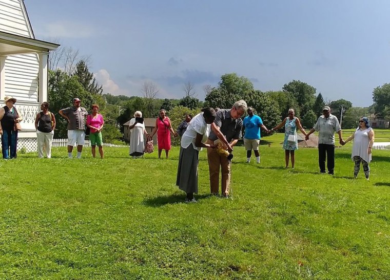 Natalie Conway and Steve Howard participate in a “libation ceremony” at Hampton Plantation.  Conway's great-great-grandmother was enslaved at the plantation, and Howard is a descendant of the plantation's owners, the Ridgely Howards.
