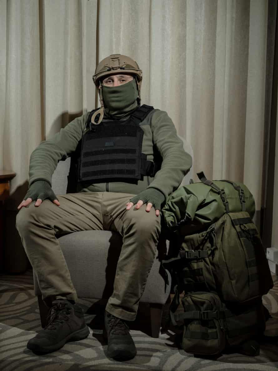 A fighter sits in a chair with his face covered