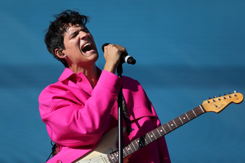 A singer in a pink suit onstage
