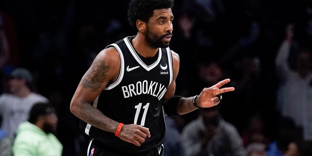 Brooklyn Nets' Kyrie Irving reacts after hitting a basket against the Cleveland Cavaliers during the first half of the opening basketball game of the NBA play-in tournament Tuesday, April 12, 2022, in New York.
