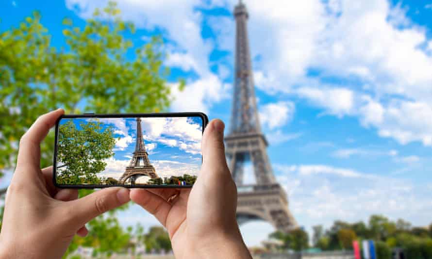Tourist takes photo of Eiffel tower in Paris, France.