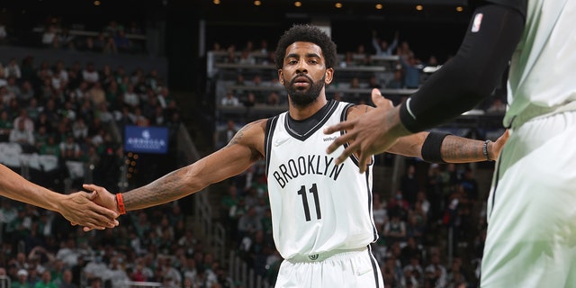 Kyrie Irving #11 of the Brooklyn Nets high fives his teammates during Round 1 Game 1 of the 2022 NBA Playoffs on April 17, 2022 at the TD Garden in Boston, Massachusetts. 