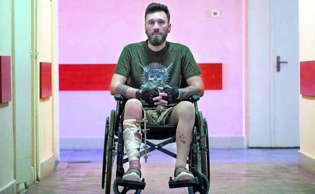 Ivan Hunchenko poses sitting in his wheelchair in one of the long corridors of the hospital on the outskirts of Lviv.