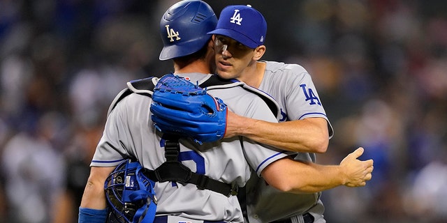 Los Angeles Dodgers starting pitcher Walker Buehler, right, celebrates his three-hit complete game with catcher Will Smith after a baseball game against the Arizona Diamondbacks, Monday, April 25, 2022, in Phoenix. The Dodgers defeated the Diamondbacks 4-0. 