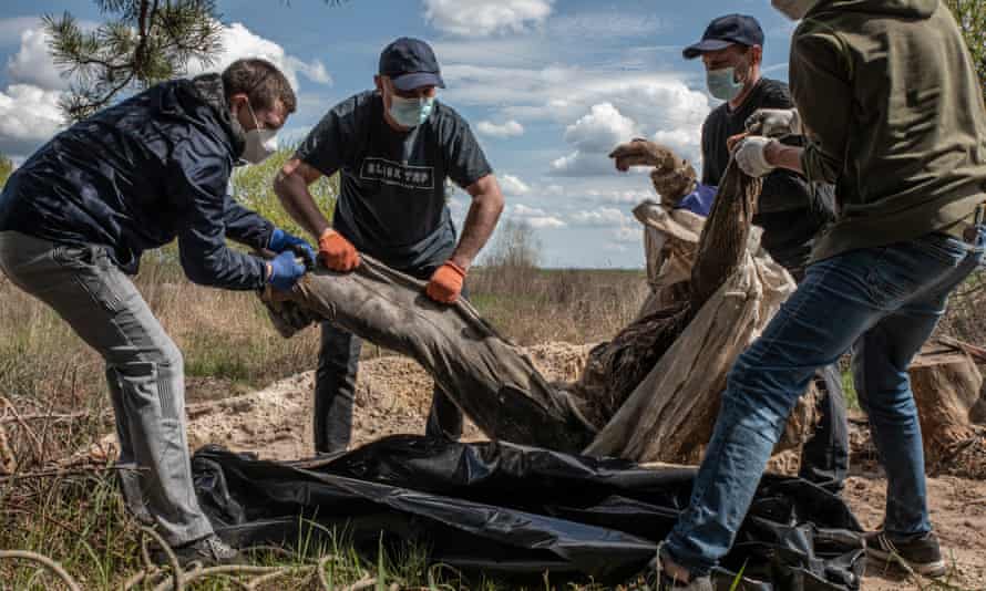 Volunteers carry an exhumed body near Borodyanka