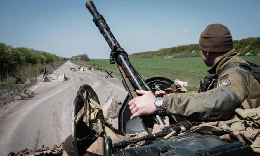 A Ukrainian soldier sits on an armored personnel carrier driving on a road near Slovyansk, eastern Ukraine