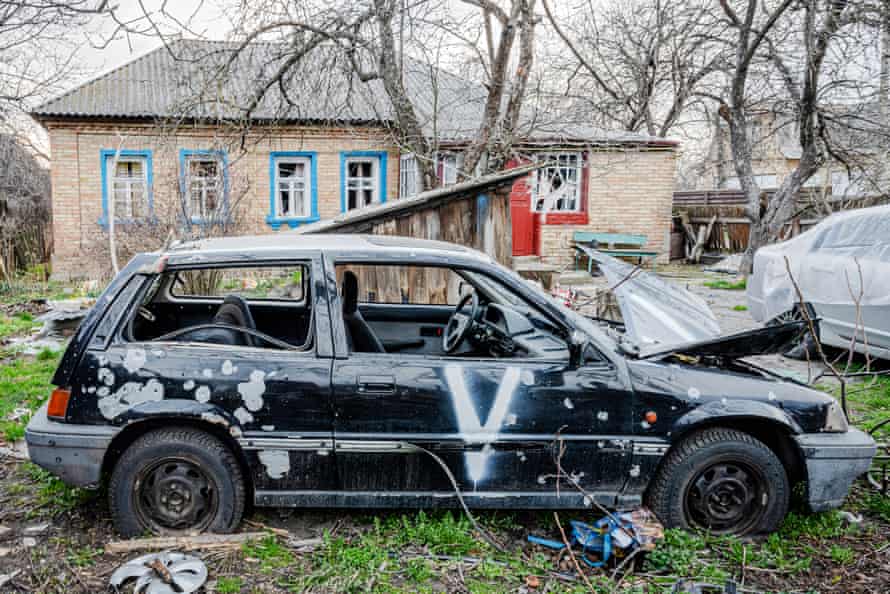 A car destroyed by Russian troops and marked with the pro-Russia 'V' symbol.