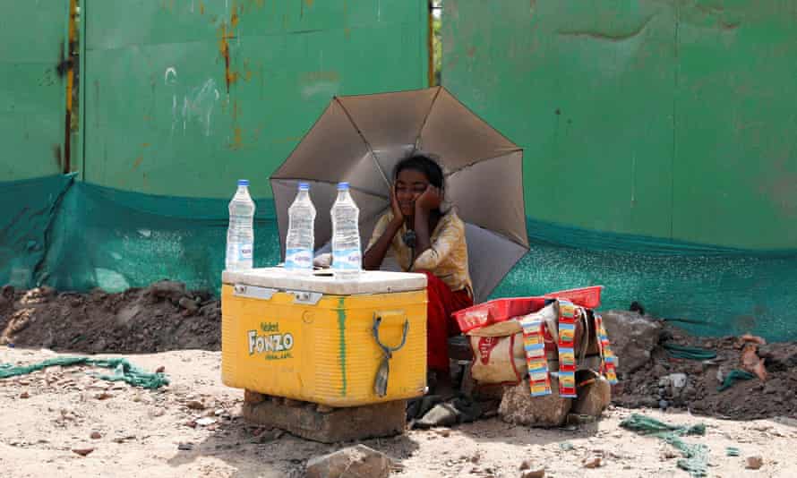 A girl in New Delhi sells water under the shade of an umbrella as a brutal heatwave swept across India and Pakistan in April.
