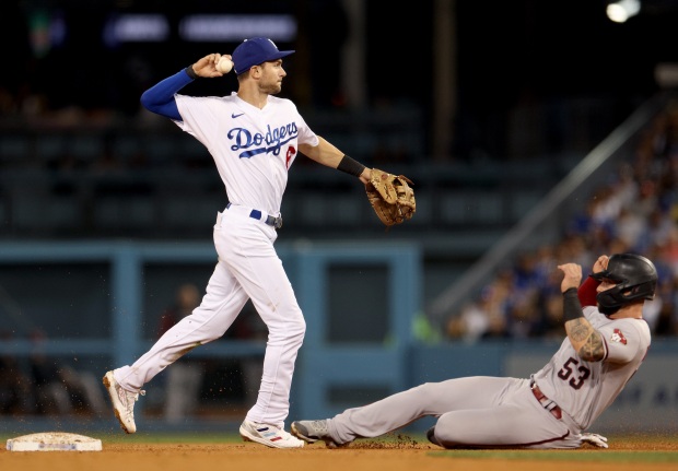 Dodgers shortstop Trea Turner throws over the Arizona Diamondbacks’ Christian...