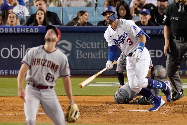 The Dodgers’ Chris Taylor runs to first as he watches...
