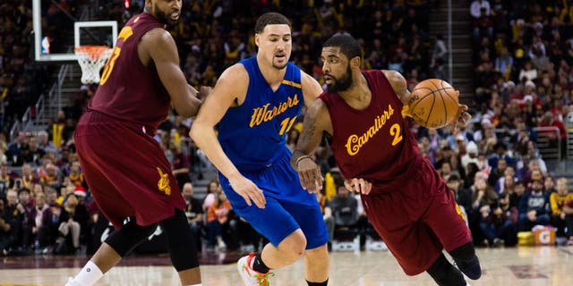 Tristan Thompson #13 sets a pick as Kyrie Irving #2 of the Cleveland Cavaliers drives around Klay Thompson #11 of the Golden State Warriors during the second half at Quicken Loans Arena on December 25, 2016 in Cleveland, Ohio.