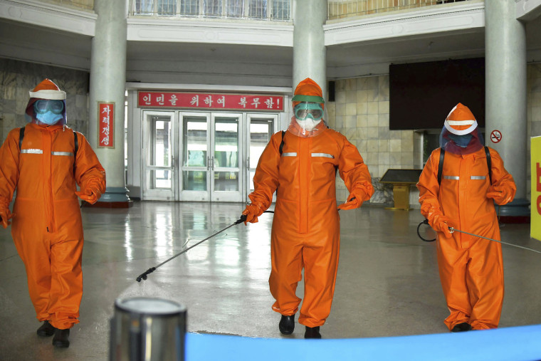 Government staff disinfect the floor of Pyongyang station on Tuesday to try and curb the spread of Covid in North Korea's capital.