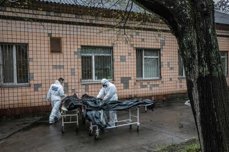 Experts from the forensic department of France's national gendarmerie and Ukrainian doctors carrying bodies of civilians killed in Bucha