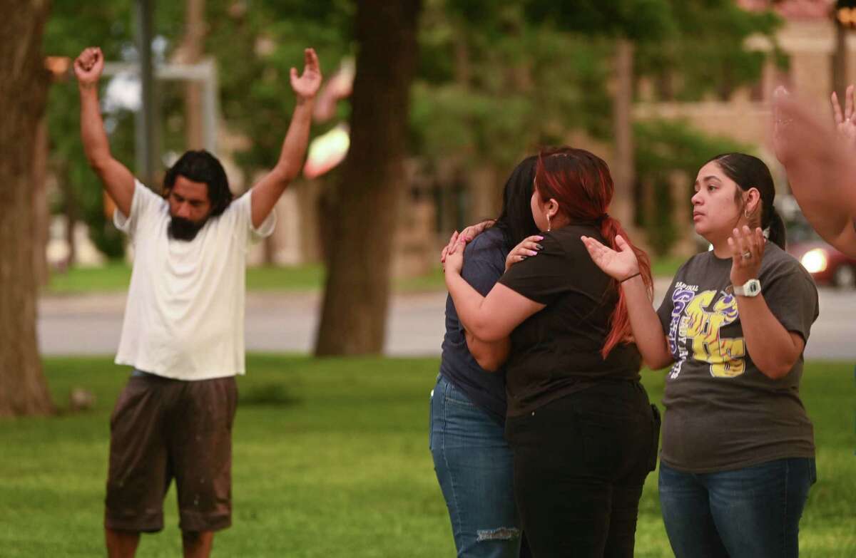 People pray and comfort one another during a vigil for the 18 children and three adults that died at a mass shooting at Robb Elementary School in Uvalde on Tuesday, May 24, 2022.