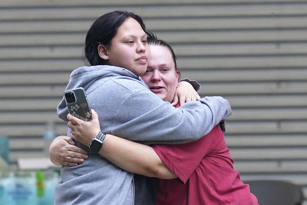 Two women hug outside the Willie de Leon Civic Center where grief counseling will be offered in Uvalde, Texas, on May 24, 2022. - A teenage gunman killed 18 young children in a shooting at an elementary school in Texas on Tuesday, in the deadliest US school shooting in years. The attack in Uvalde, Texas -- a small community about an hour from the Mexican border -- is the latest in a spree of deadly shootings in America, where horror at the cycle of gun violence has failed to spur action to end it. (Photo by allison dinner / AFP) (Photo by ALLISON DINNER/AFP via Getty Images)