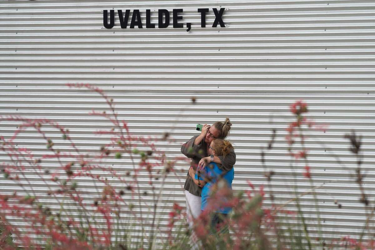 A woman cries and hugs a young girl while on the phone outside the Willie de Leon Civic Center where grief counseling will be offered in Uvalde, Texas, on May 24, 2022. - A teenage gunman killed 18 young children in a shooting at an elementary school in Texas on Tuesday, in the deadliest US school shooting in years. The attack in Uvalde, Texas -- a small community about an hour from the Mexican border -- is the latest in a spree of deadly shootings in America, where horror at the cycle of gun violence has failed to spur action to end it. (Photo by allison dinner / AFP) (Photo by ALLISON DINNER/AFP via Getty Images)
