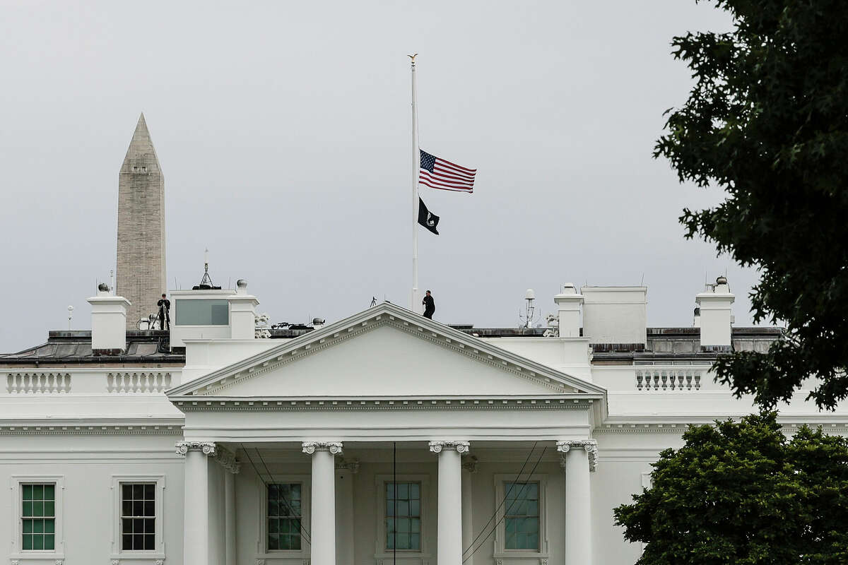 WASHINGTON, DC - MAY 24: A U.S. Secret Service officer lowers the American flag to half staff over the White House following the recent mass shooting at a Texas elementary school on May 24, 2022 in Washington, DC. Fifteen people are dead - including 14 children and one teacher - in the massacre at the Robb Elementary School in Uvalde, Texas, according to published reports. (Photo by Anna Moneymaker/Getty Images)