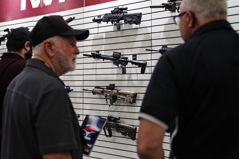 Visitors look at rifles at the annual NRA convention Friday. 