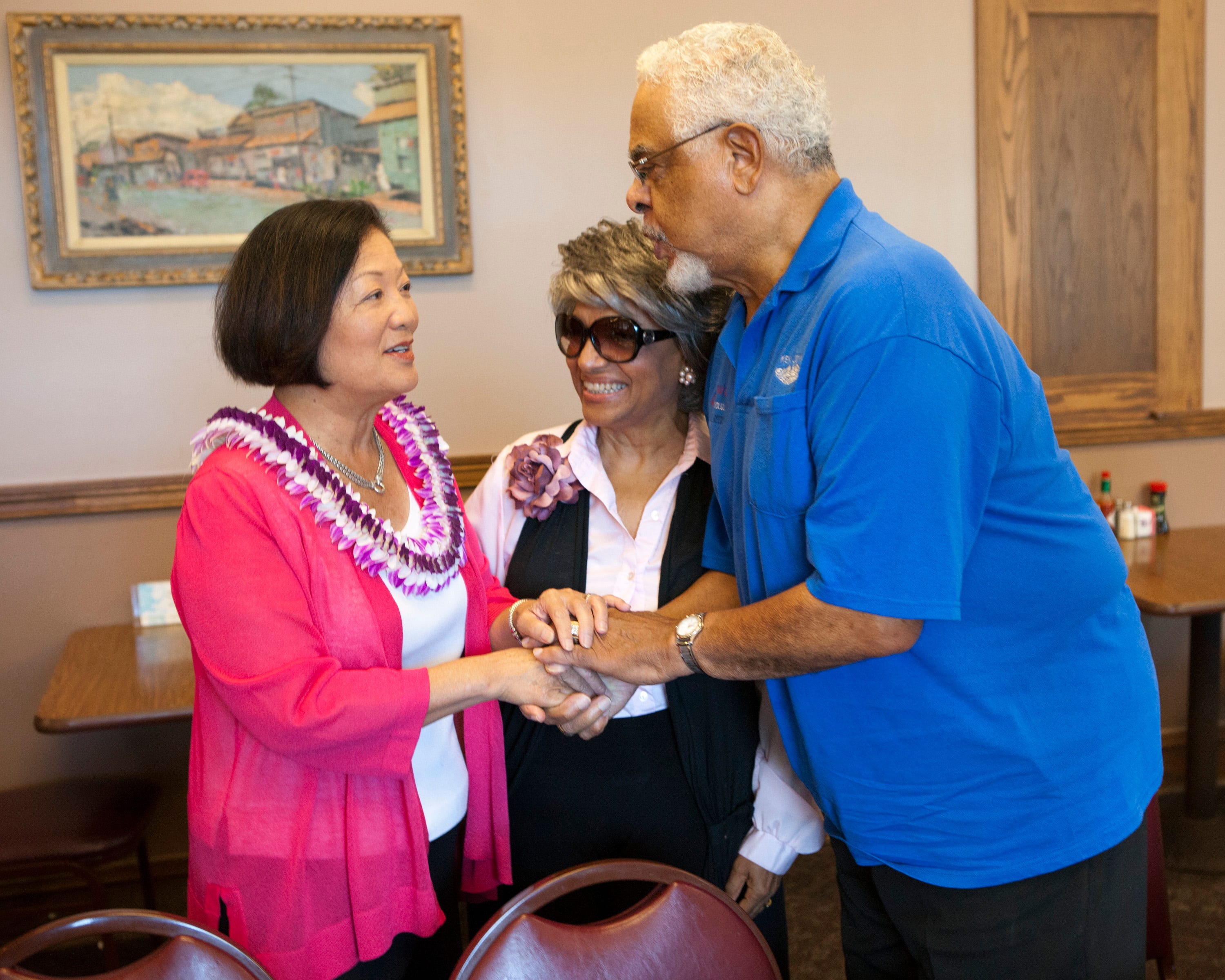 Democratic US Senate candidate Maize Hirono, left, greets Marsha Joyner, center, and Korean War veteran Kenneth Joyner, 81, at the Like Like Drive Inn restaurant Nov. 6, 2012, in Honolulu.