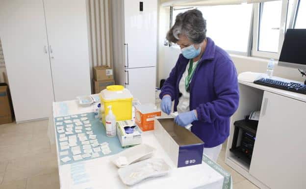 Stock image of health workers preparing vaccines against covid-19.