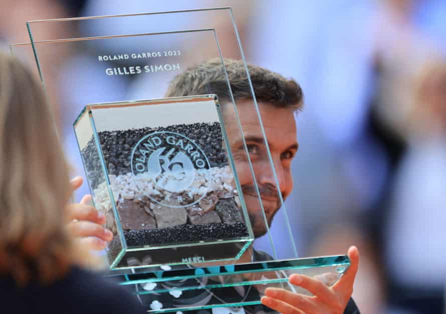 France's Gilles Simon poses with an award after his last match at Roland Garros, after losing his third round match against Croatia's Marin Cilic.
