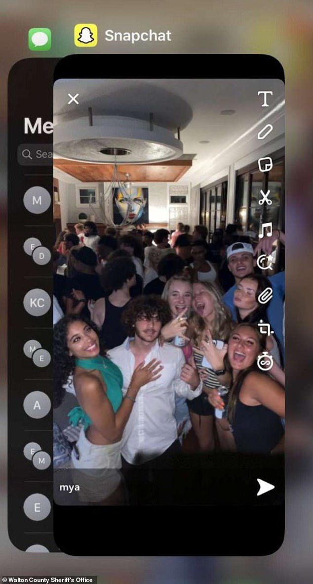 A large group posted for a pictured inside the house as they party raged on behind them