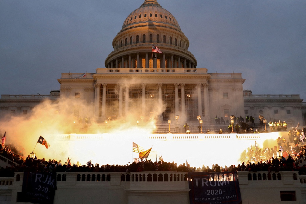 An explosion caused by a police munition is seen while supporters of US President Donald Trump riot at the US Capitol Building in Washington, US, January 6, 2021.