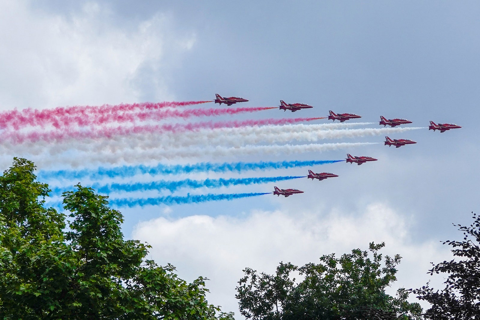 The Royal Air Force Aerobatic Team the Red Arrows fly in formation during a flypast.